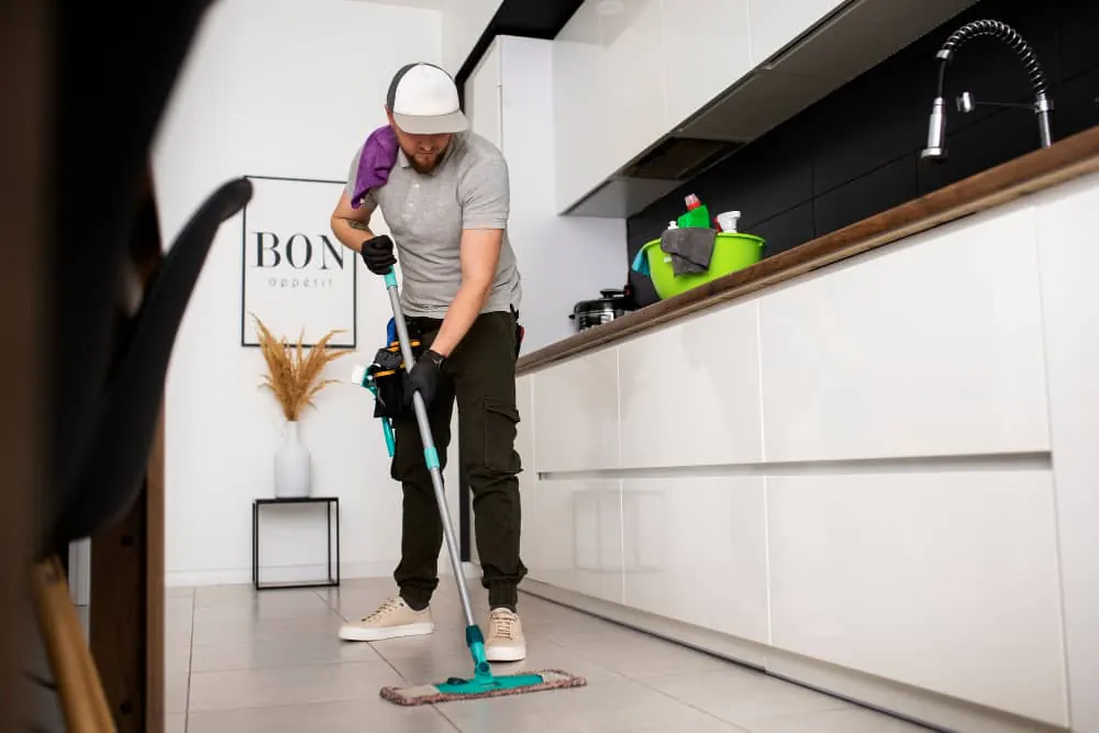 Mopping the floor of a fitted kitchen