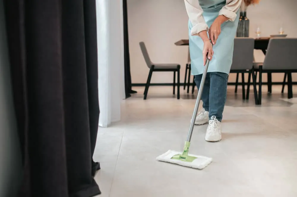 Flat-mopping a tiled floor in a dining area